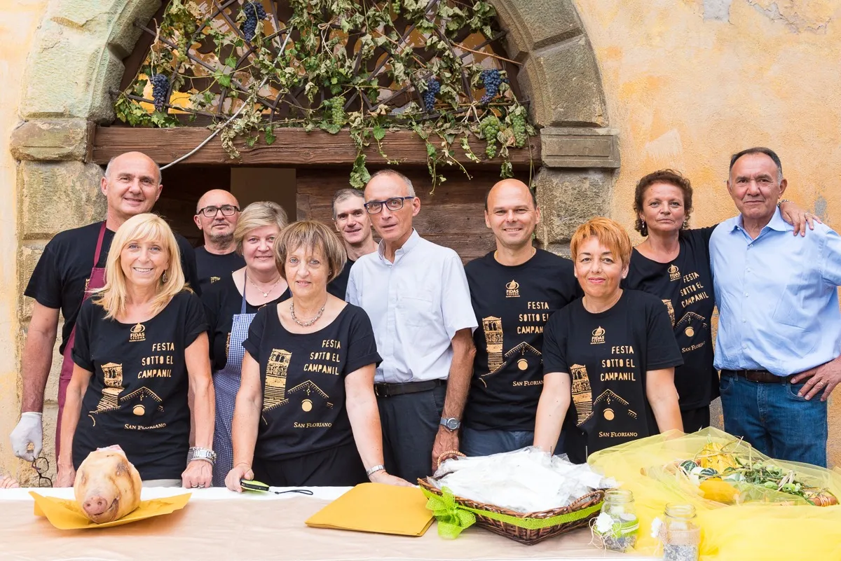 I volontari della cucina con il parroco davanti allo stand gastronomico